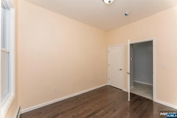 a view of an empty room with wooden floor