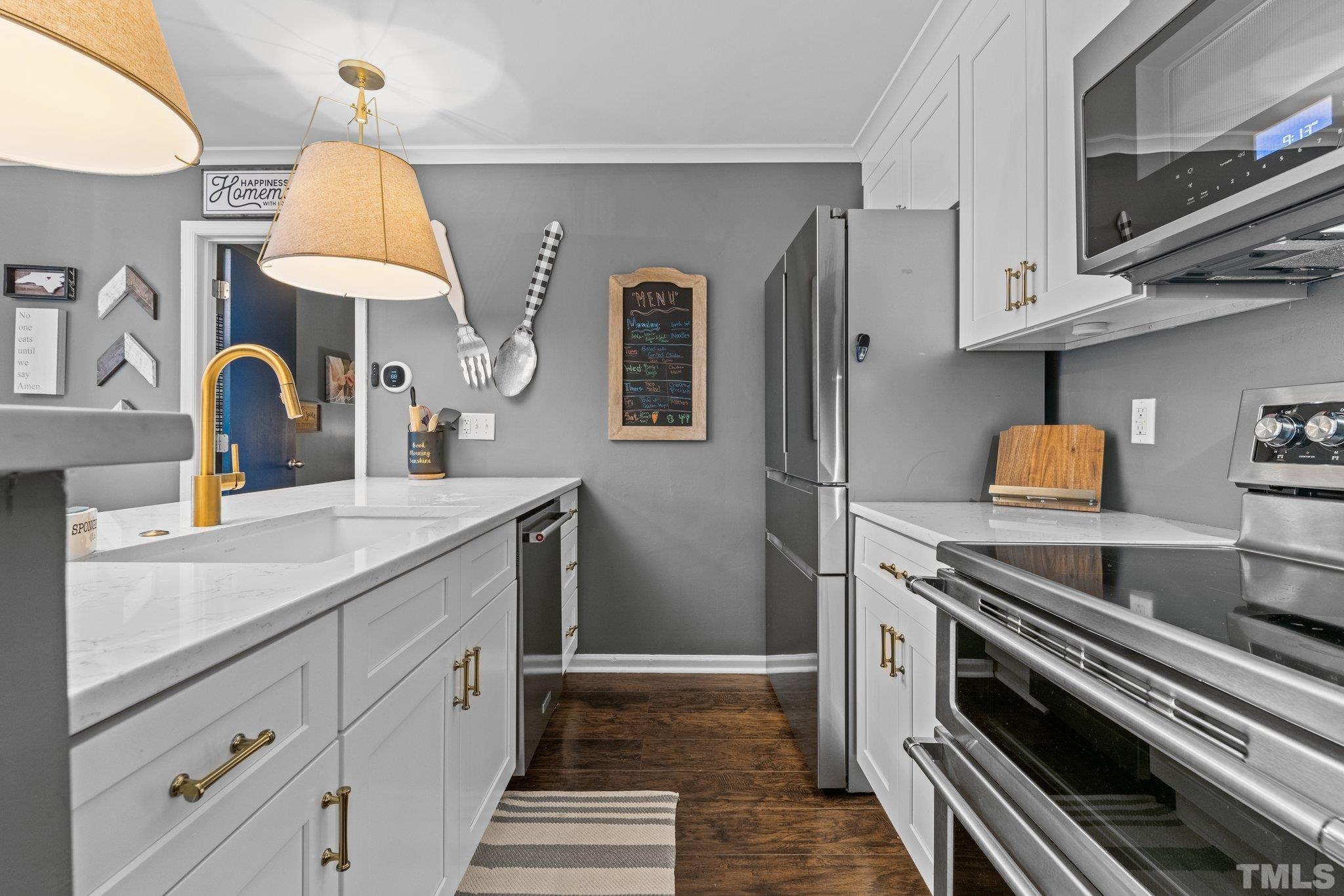 3231 Mill Run, Unit 3231 Raleigh, NC 27612 - Photo 14 of 28 a kitchen with stainless steel appliances a sink dishwasher a refrigerator and cabinets