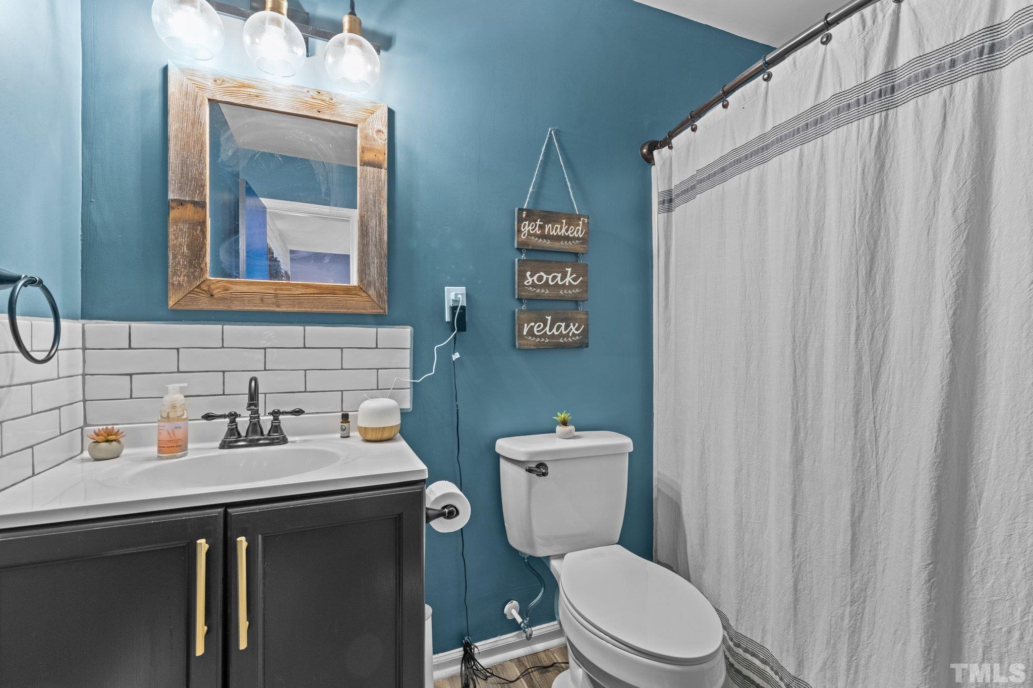 3231 Mill Run, Unit 3231 Raleigh, NC 27612 - Photo 20 of 28 a bathroom with a toilet a sink and a mirror