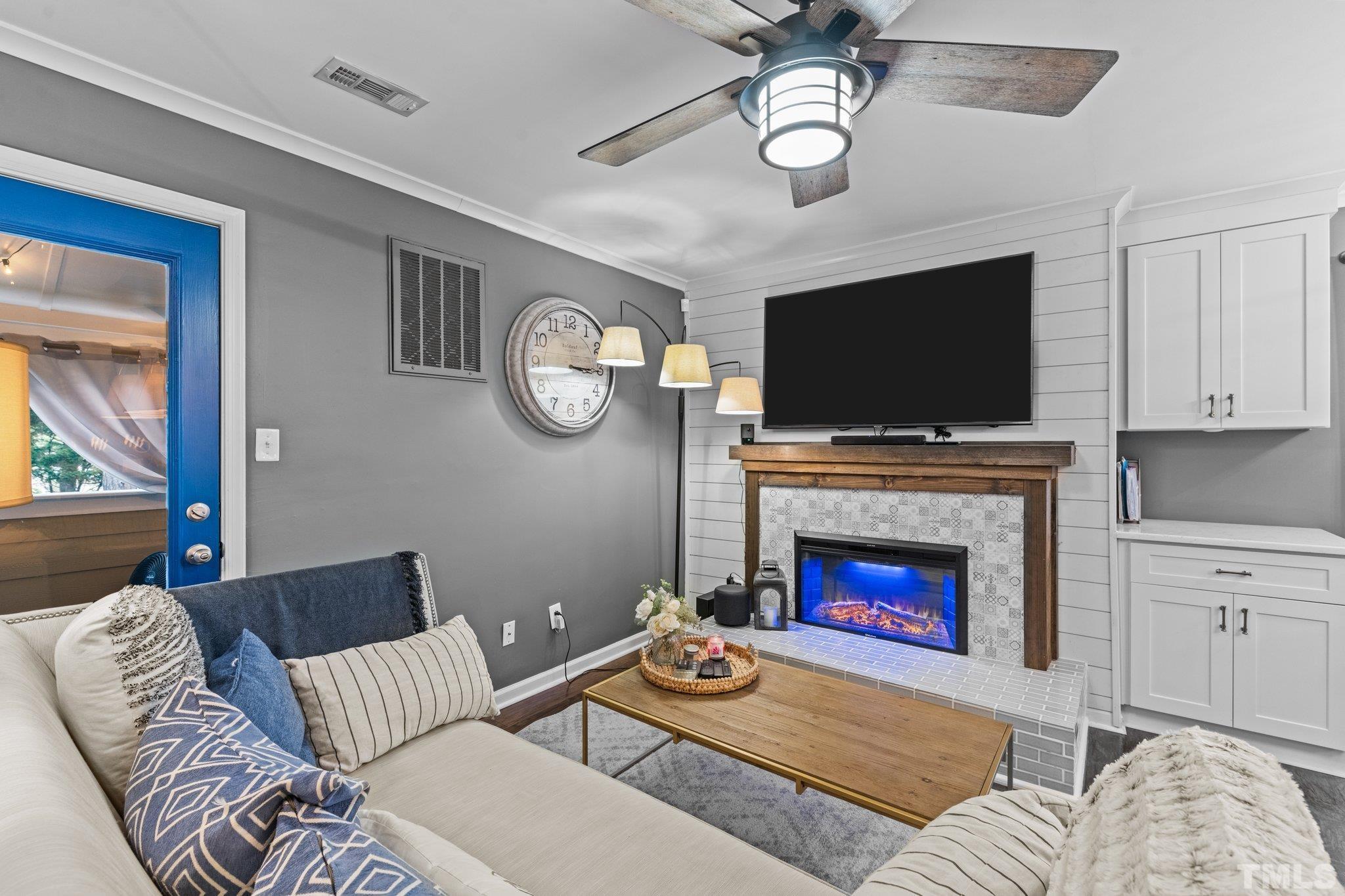 3231 Mill Run, Unit 3231 Raleigh, NC 27612 - Photo 7 of 28 a living room with furniture a fireplace and a flat screen tv