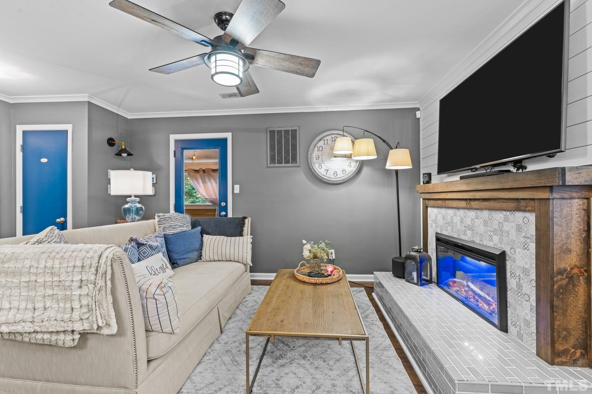 3231 Mill Run, Unit 3231 Raleigh, NC 27612 - Photo 8 of 28 a living room with furniture a flat screen tv and a fireplace