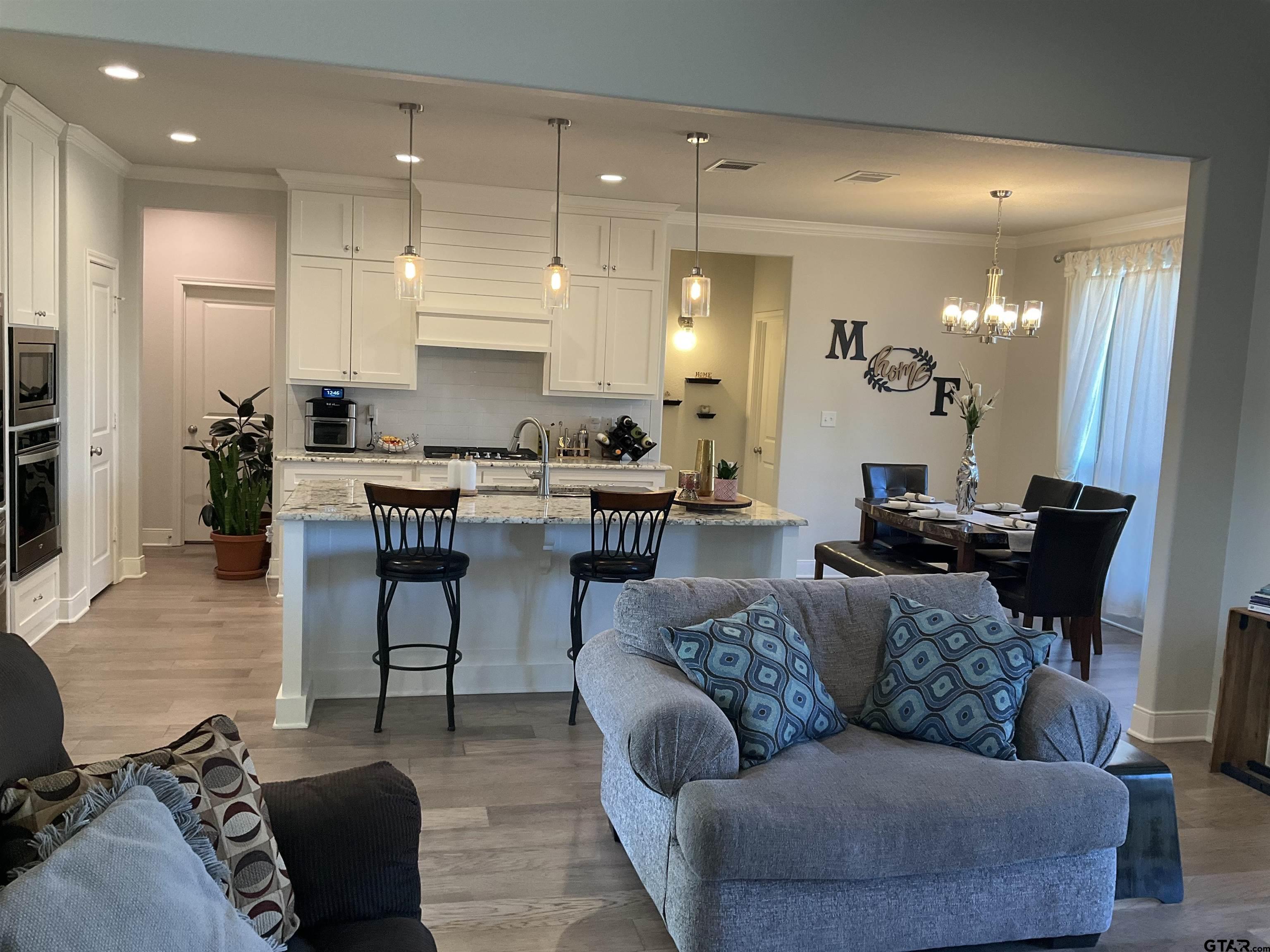 11978 Gillian Court Tyler, TX 75703 - Photo 8 of 36 a living room kitchen with furniture and a wooden floor