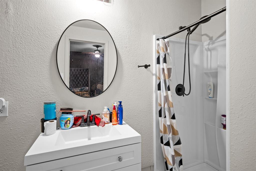 2133 Pleasant Drive Dallas, TX 75227 - Photo 25 of 40 Bathroom with a textured wall, a shower stall, and vanity