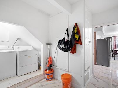 2133 Pleasant Drive Dallas, TX 75227 - Photo 26 of 40 Laundry room with washing machine and dryer and light marble finish flooring