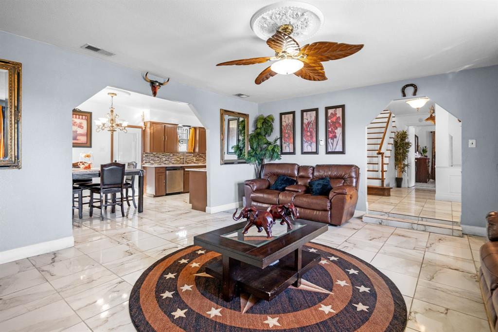 2133 Pleasant Drive Dallas, TX 75227 - Photo 7 of 40 Living area with a chandelier, a ceiling fan, arched walkways, and stairway