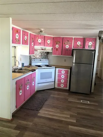 a kitchen with stainless steel appliances a sink cabinets and wooden floor