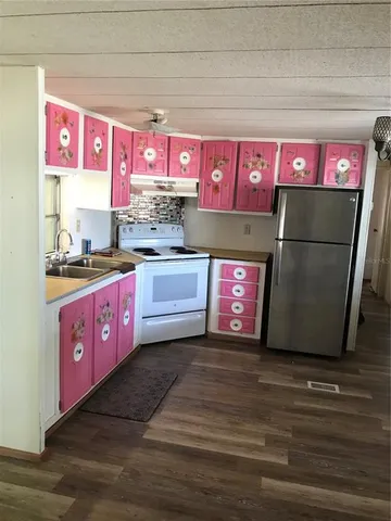 a kitchen with stainless steel appliances a sink cabinets and wooden floor