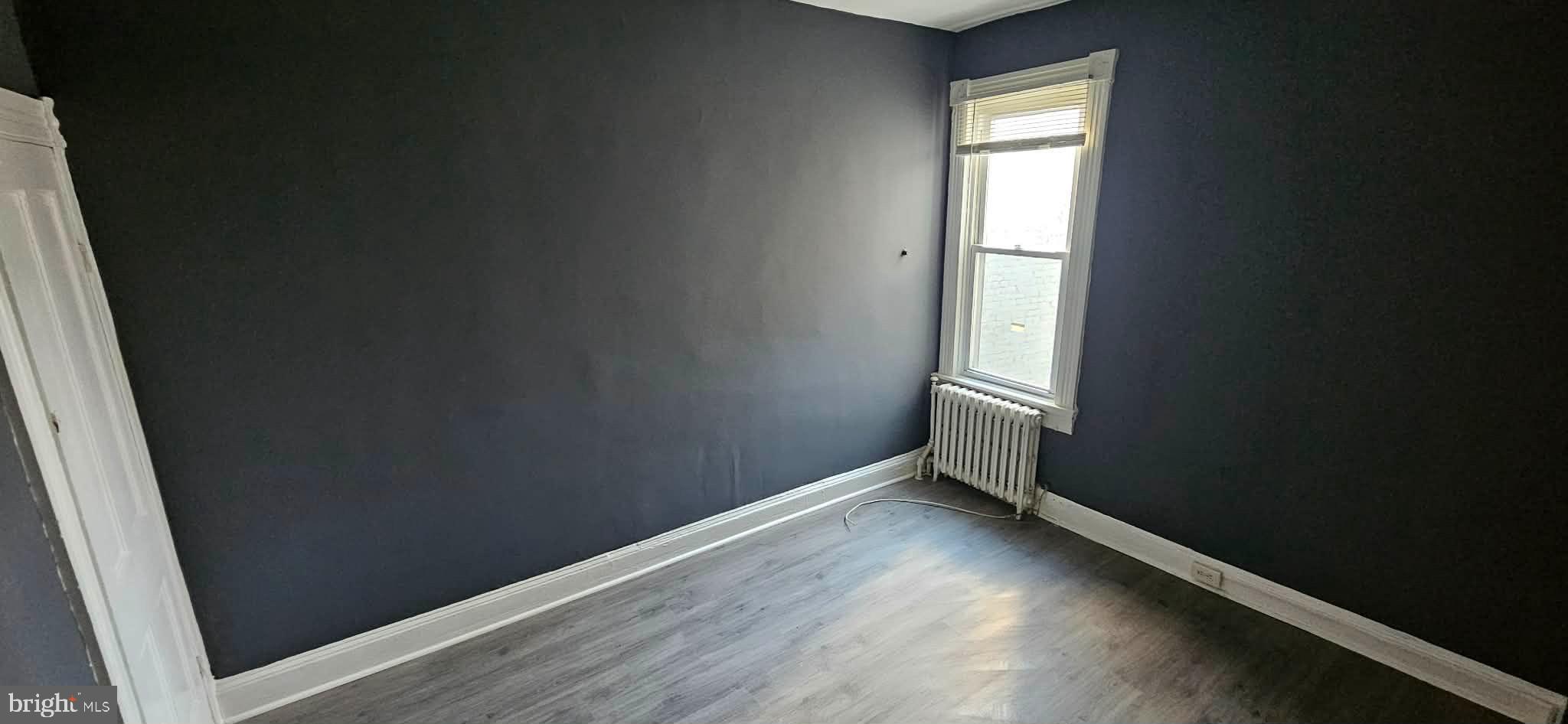 1519 North Wolfe Street Baltimore, MD 21213 - Photo 5 of 7 an empty room with wooden floor and windows
