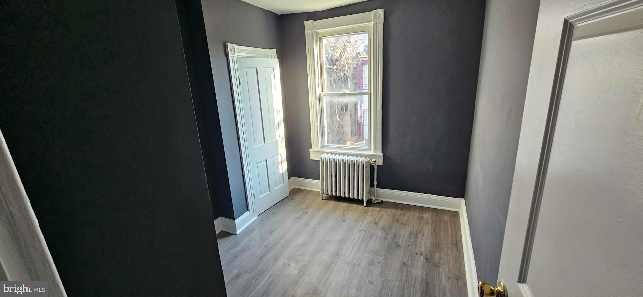 1519 North Wolfe Street Baltimore, MD 21213 - Photo 7 of 7 an empty room with wooden floor and a window