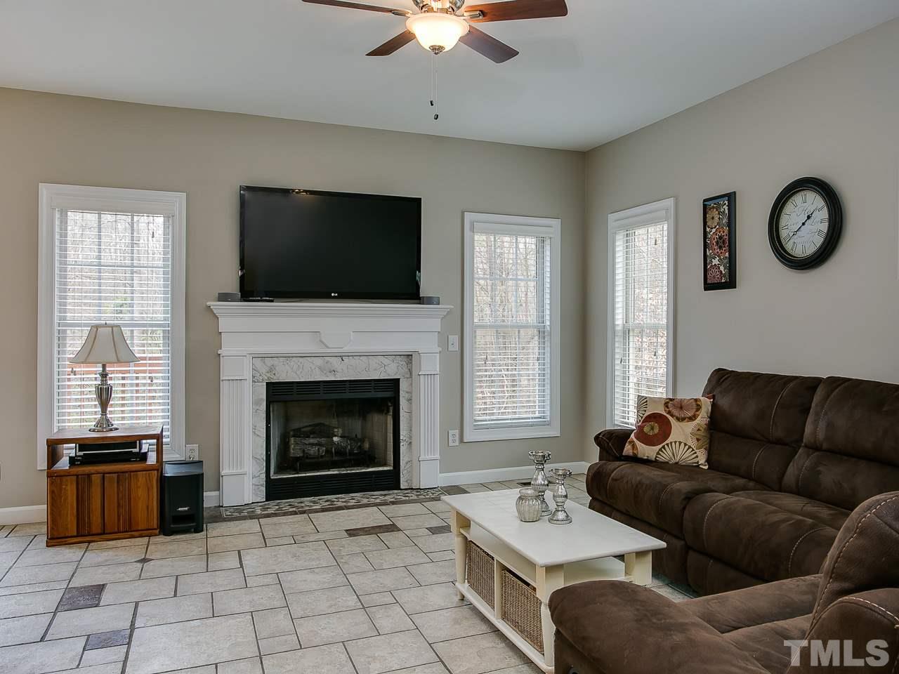 832 Kings Cross Way Raleigh, NC 27615 - Photo 11 of 25 a living room with furniture a fireplace and a flat screen tv