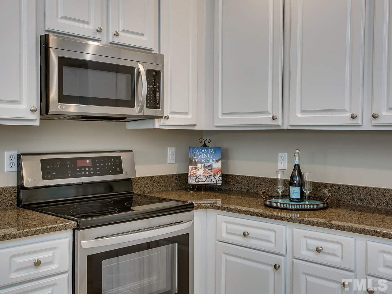 832 Kings Cross Way Raleigh, NC 27615 - Photo 9 of 25 a kitchen with granite countertop white cabinets and stainless steel appliances