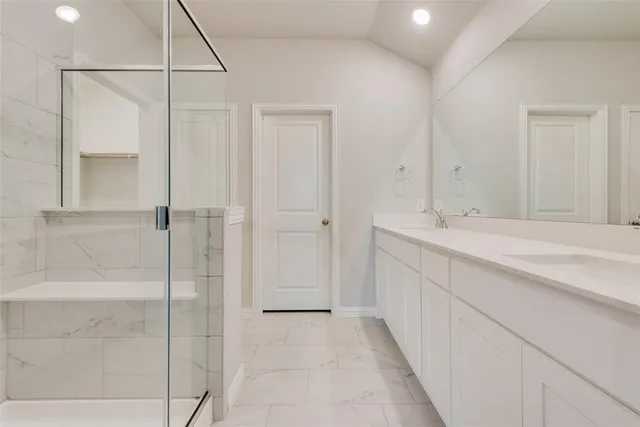 a bathroom with a double vanity sink and shower