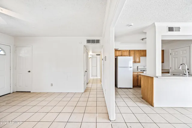 a view of a kitchen with refrigerator and wooden cabinets