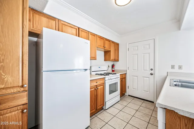 a kitchen with a refrigerator a stove top oven and a sink