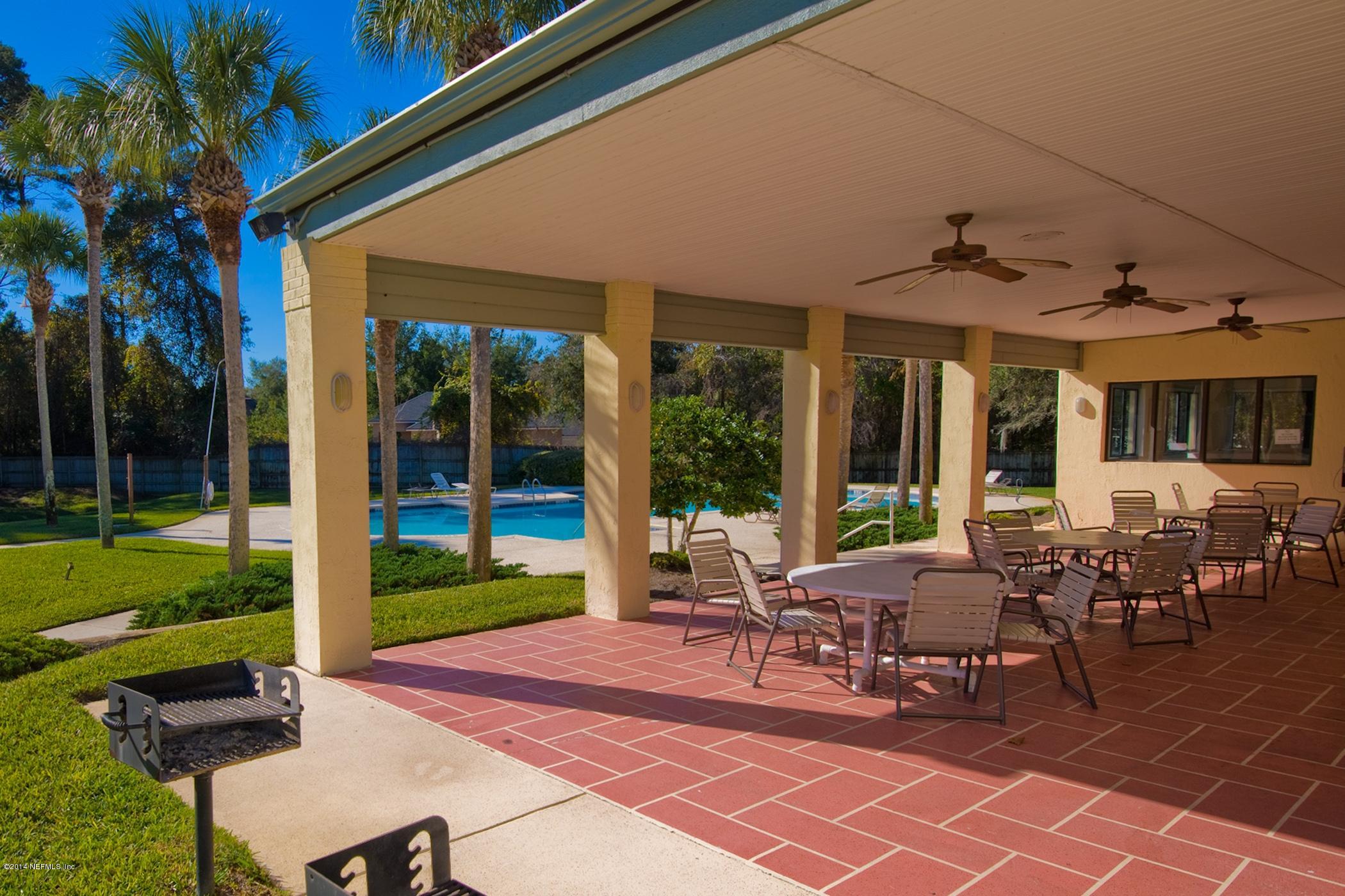 3541 Kings Road South St. Augustine, FL 32086 - Photo 35 of 39 a view of a patio with table and chairs potted plants and floor to ceiling window