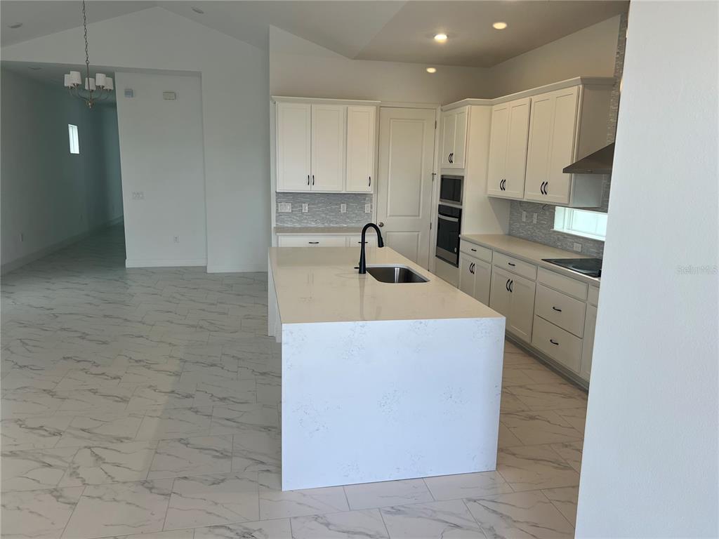 10171 Pearson Avenue Orlando, FL 32827 - Photo 2 of 16 a kitchen with stainless steel appliances granite countertop a sink a stove and a refrigerator