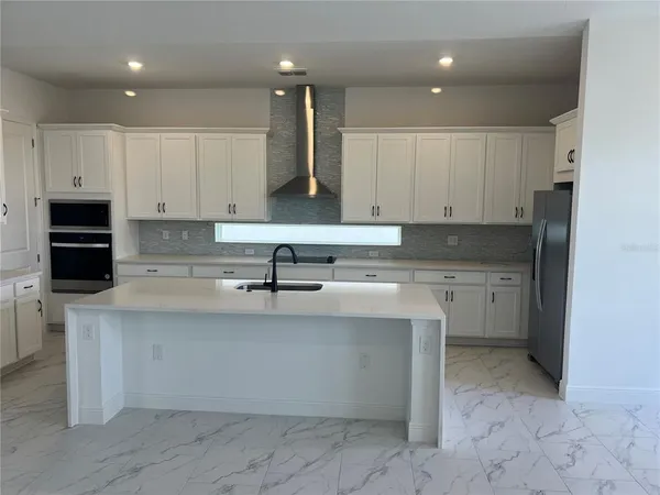 a kitchen with stainless steel appliances granite countertop a sink a stove and cabinets