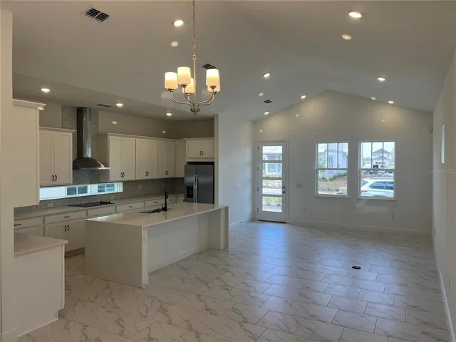 a large kitchen with stainless steel appliances a large counter top a sink and a dishwasher