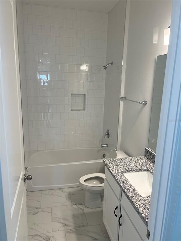 10171 Pearson Avenue Orlando, FL 32827 - Photo 9 of 16 a bathroom with a granite countertop sink a toilet and shower
