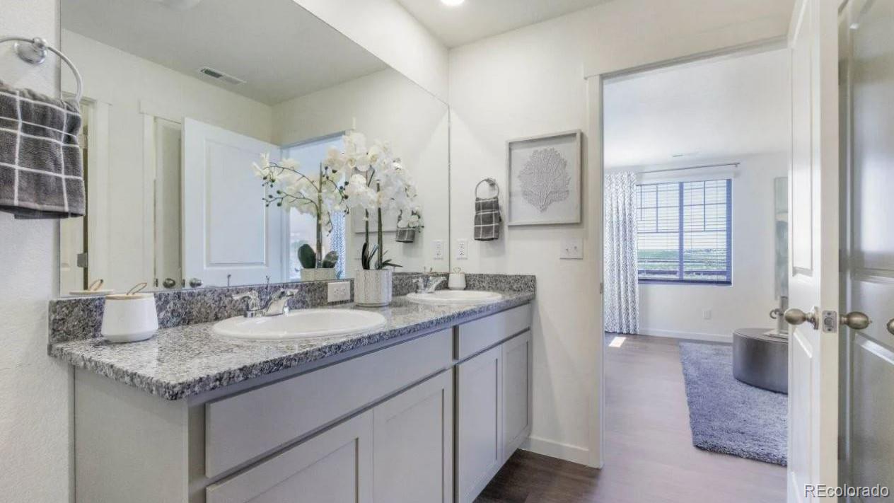 831 South Apex Avenue Fort Lupton, CO 80621 - Photo 11 of 18 a bathroom with a granite countertop sink and a mirror