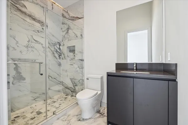 a bathroom with a granite countertop sink toilet and shower