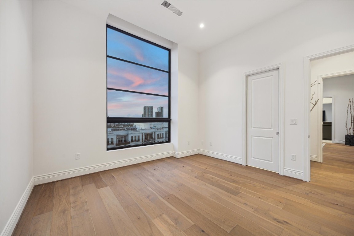2323 San Felipe Street, Unit 1101 Houston, TX 77019 - Photo 15 of 24 a view of an empty room with wooden floor and a window