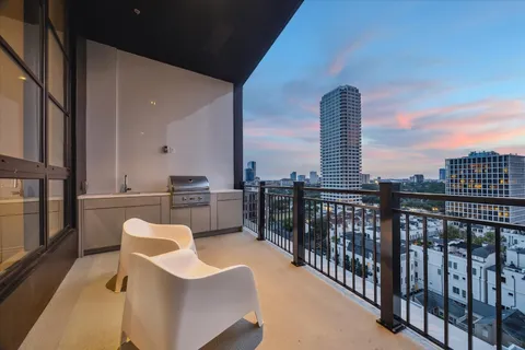 a balcony with furniture and a floor to ceiling window