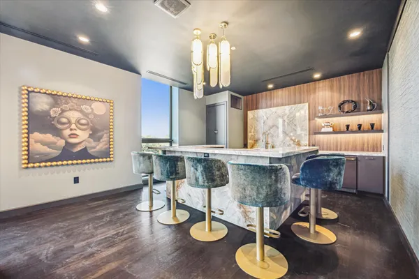 a kitchen with stainless steel appliances kitchen island granite countertop a dining table and chairs with wooden floor