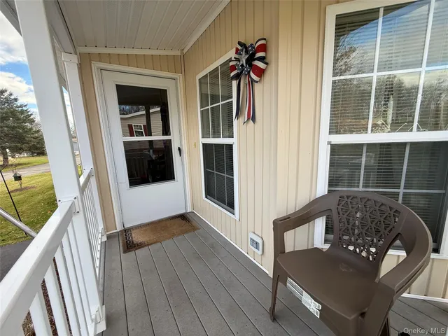 a view of a balcony with wooden floor and furniture