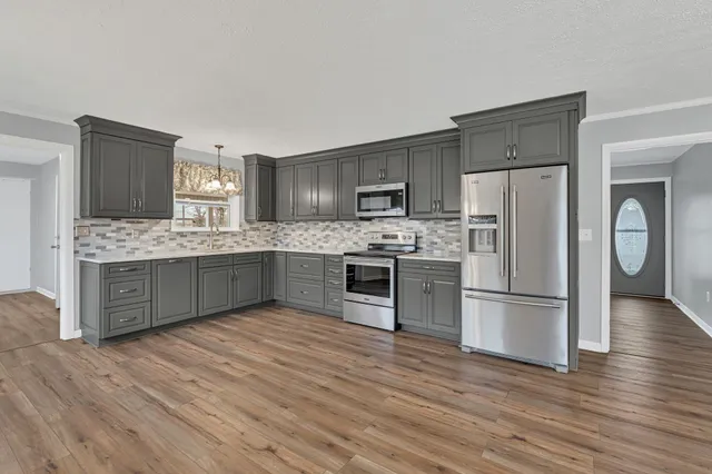 a kitchen with stainless steel appliances kitchen island granite countertop a refrigerator stove and oven