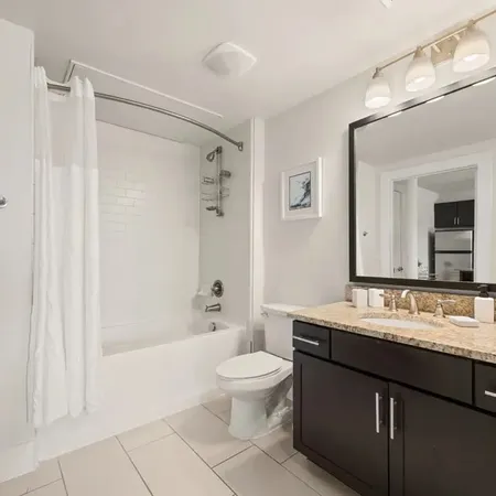 a bathroom with a double vanity sink toilet mirror and shower