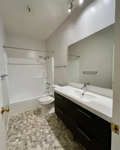 a bathroom with a double vanity sink toilet and shower