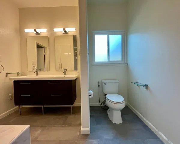 a bathroom with a toilet sink and mirror