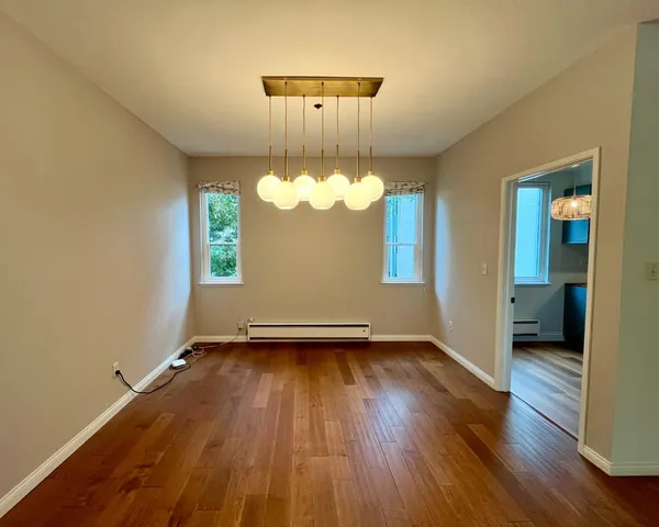 a view of a room with wooden floor a sink and a window
