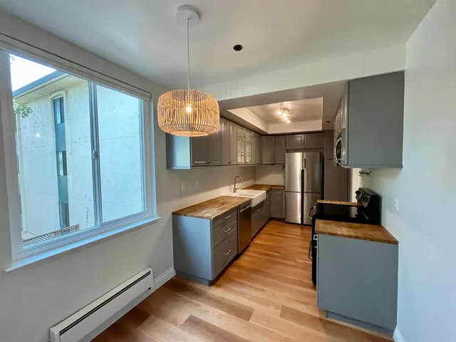 a large kitchen with kitchen island a large counter space a sink and stainless steel appliances