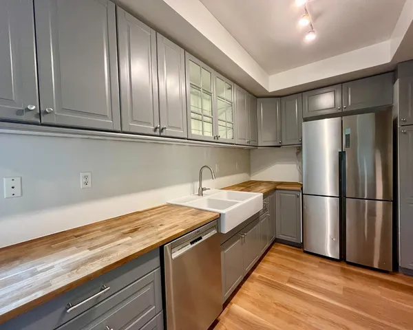 a kitchen with granite countertop a refrigerator and a sink