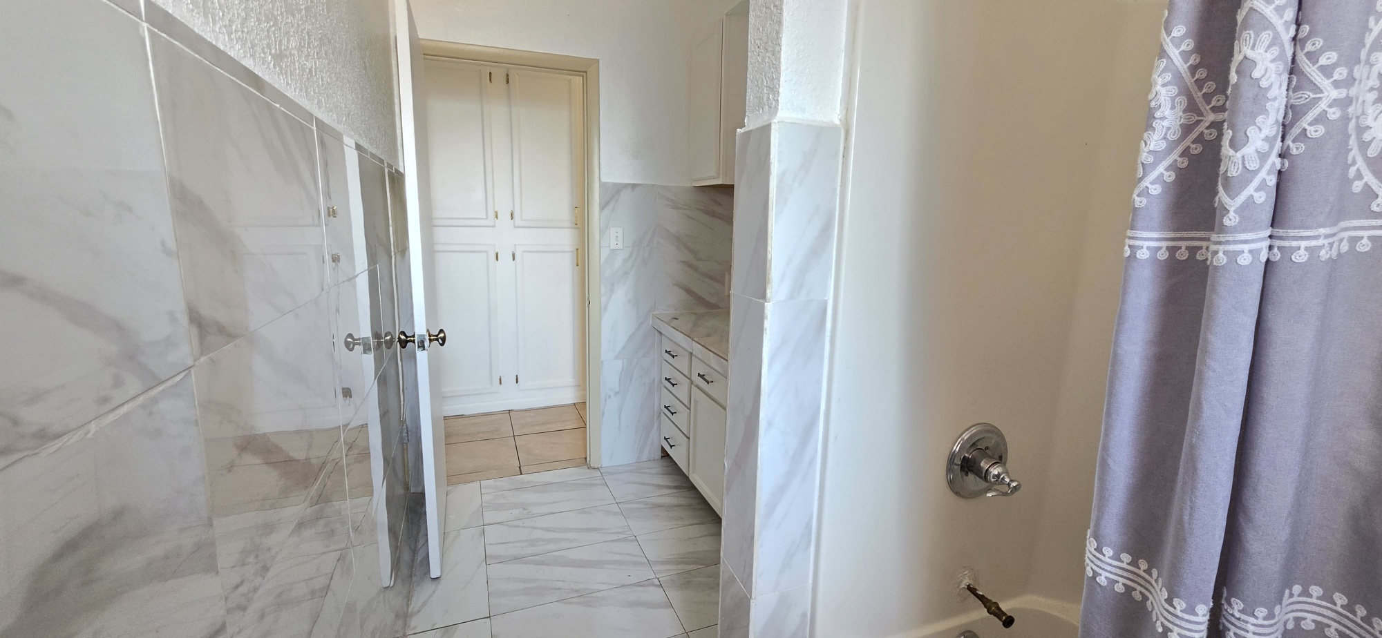 107903 South 4570 Road Sallisaw, OK 74955 - Photo 22 of 35 Bathroom featuring white tile walls, a built-in white vanity with drawers, and a white built-in storage cabinet