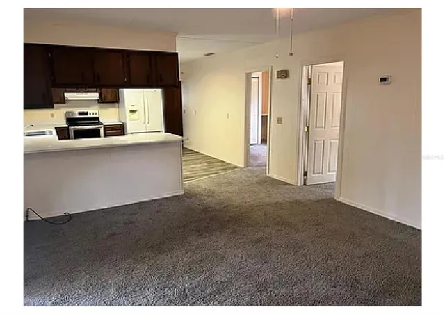 a living room with stainless steel appliances kitchen island cabinets and a couch