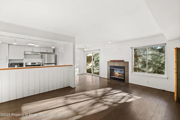 a view of a livingroom with wooden floor and a fireplace