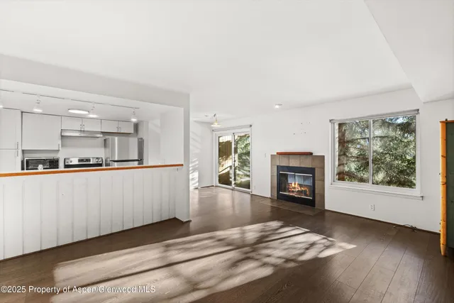a view of a livingroom with wooden floor and a fireplace