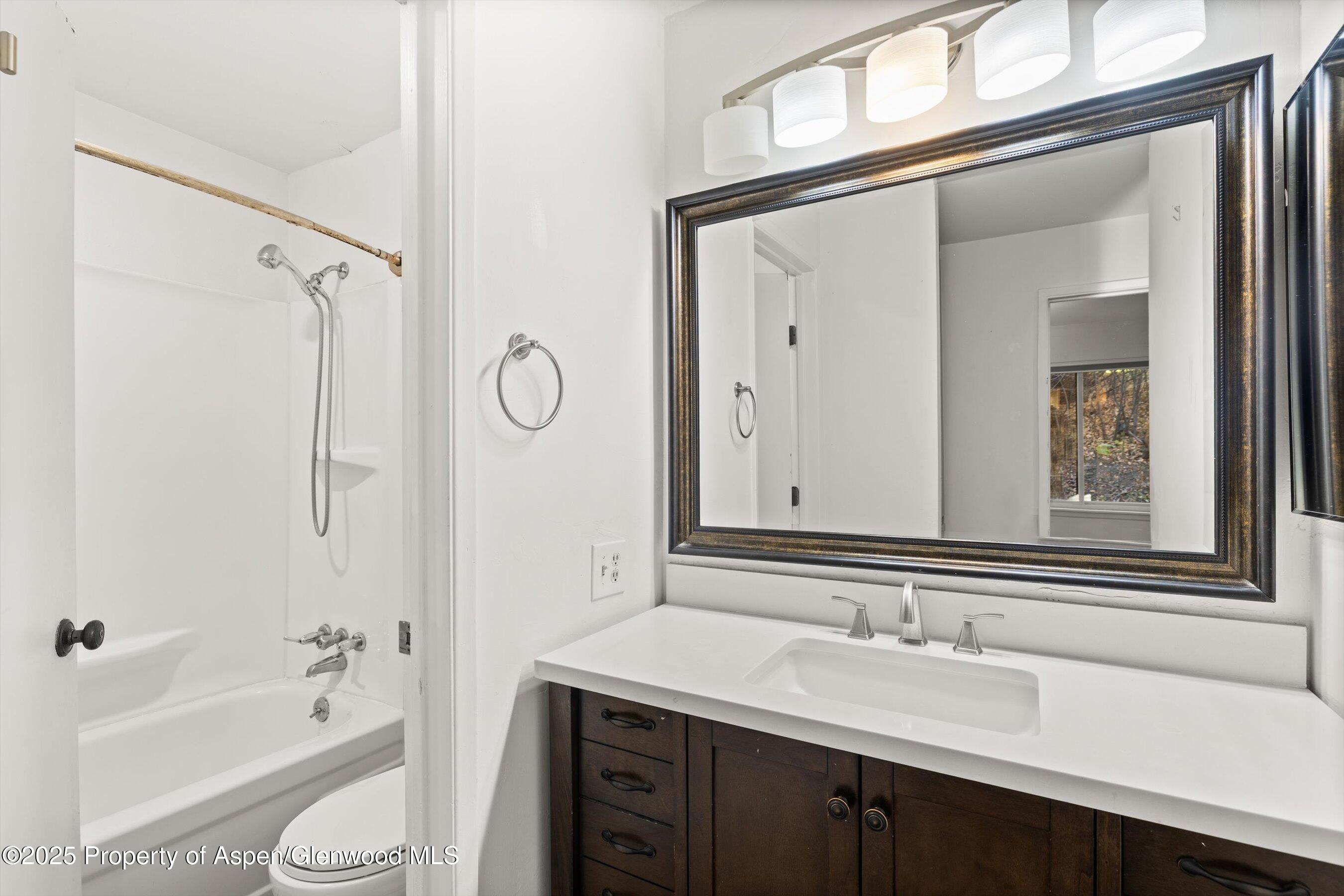 35 Lower Woodbridge Road, Unit V/177 Snowmass Village, CO 81615 - Photo 13 of 15 a bathroom with a granite countertop sink mirror toilet and bathtub