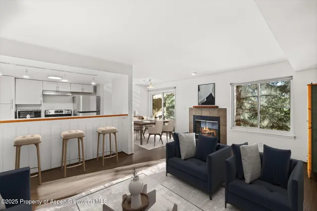 a living room with furniture a fireplace and a large window