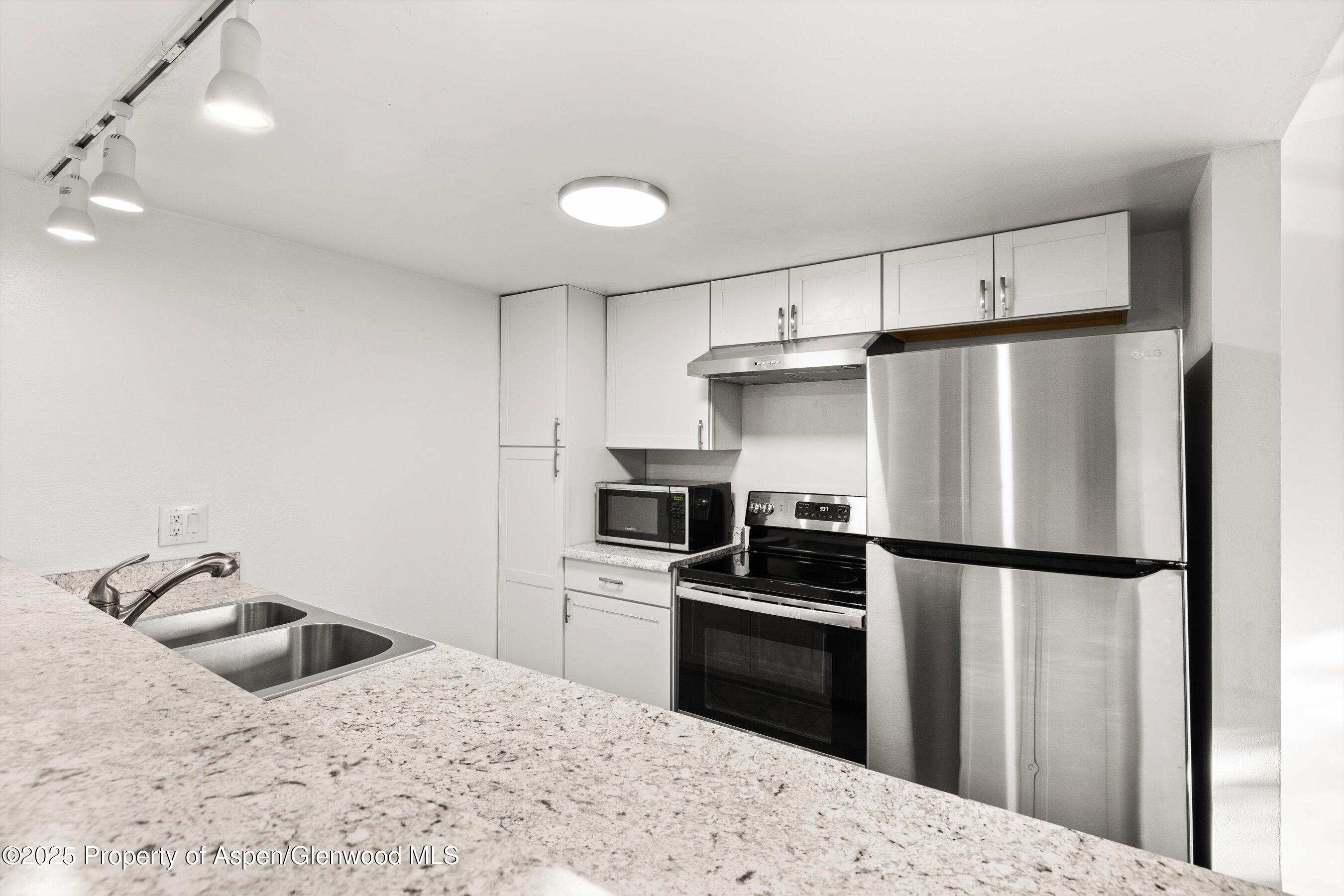 35 Lower Woodbridge Road, Unit V/177 Snowmass Village, CO 81615 - Photo 6 of 15 a kitchen with granite countertop a refrigerator and a sink