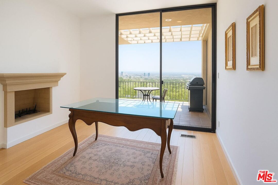 3873 Beverly Ridge Drive Sherman Oaks, CA 91423 - Photo 11 of 15 a living room with a table chair and a fireplace