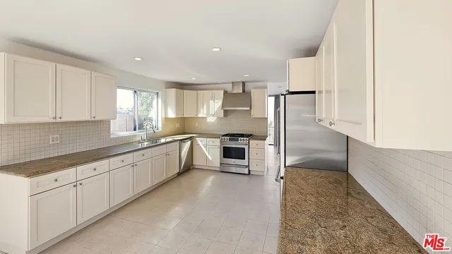 a stove top oven sitting inside of a kitchen