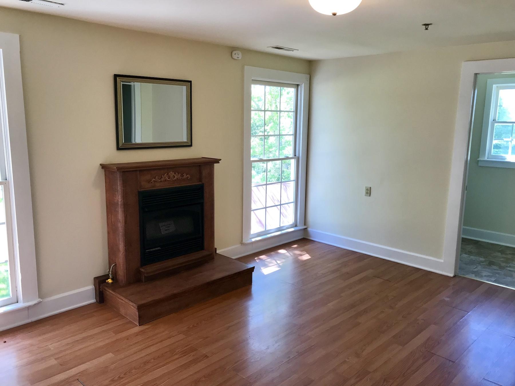 2503 Huffville Road Pilot, VA 24138 - Photo 17 of 26 an empty room with wooden floor a fireplace and windows