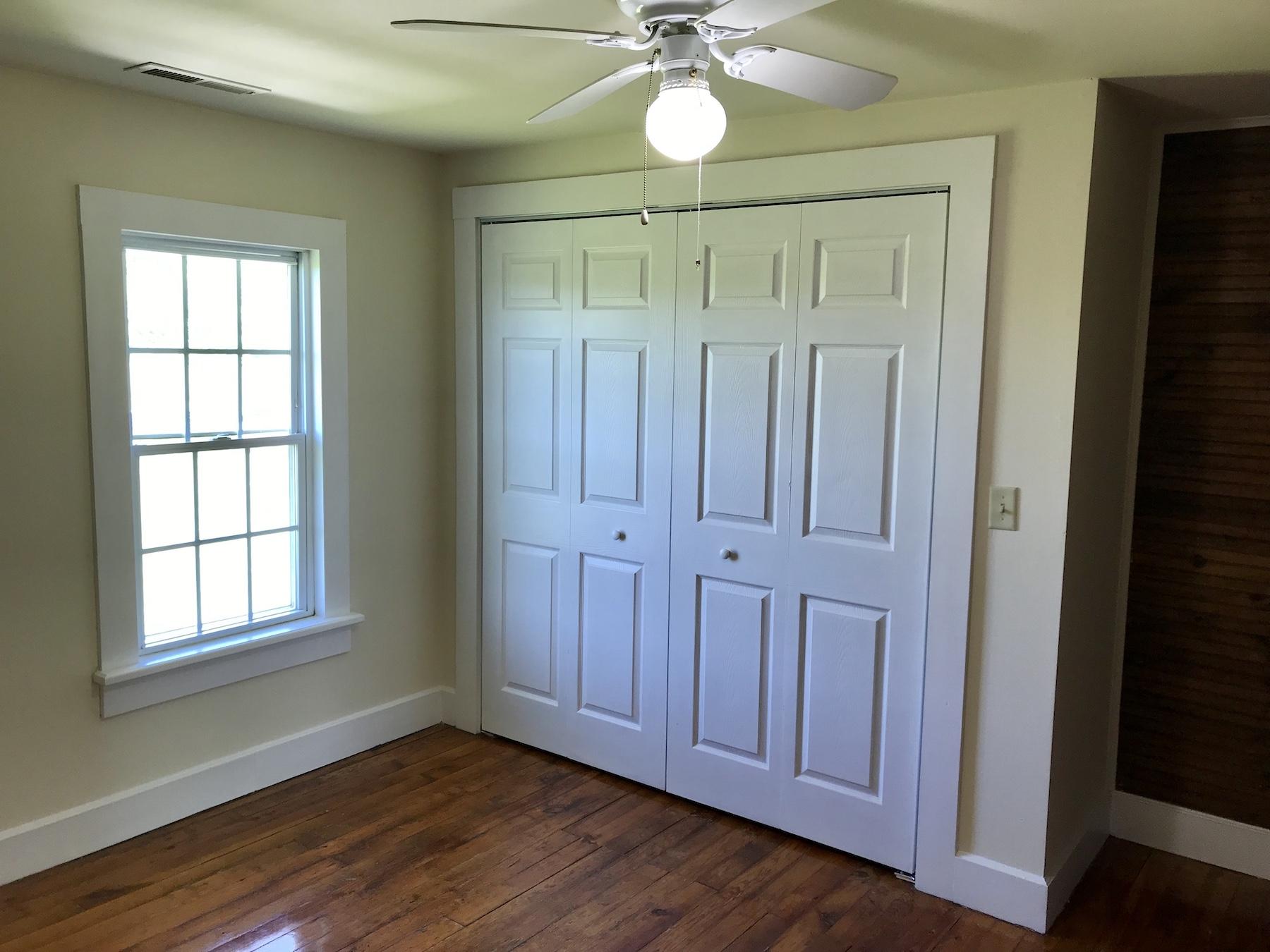 2503 Huffville Road Pilot, VA 24138 - Photo 20 of 26 an empty room with wooden floor fan and windows