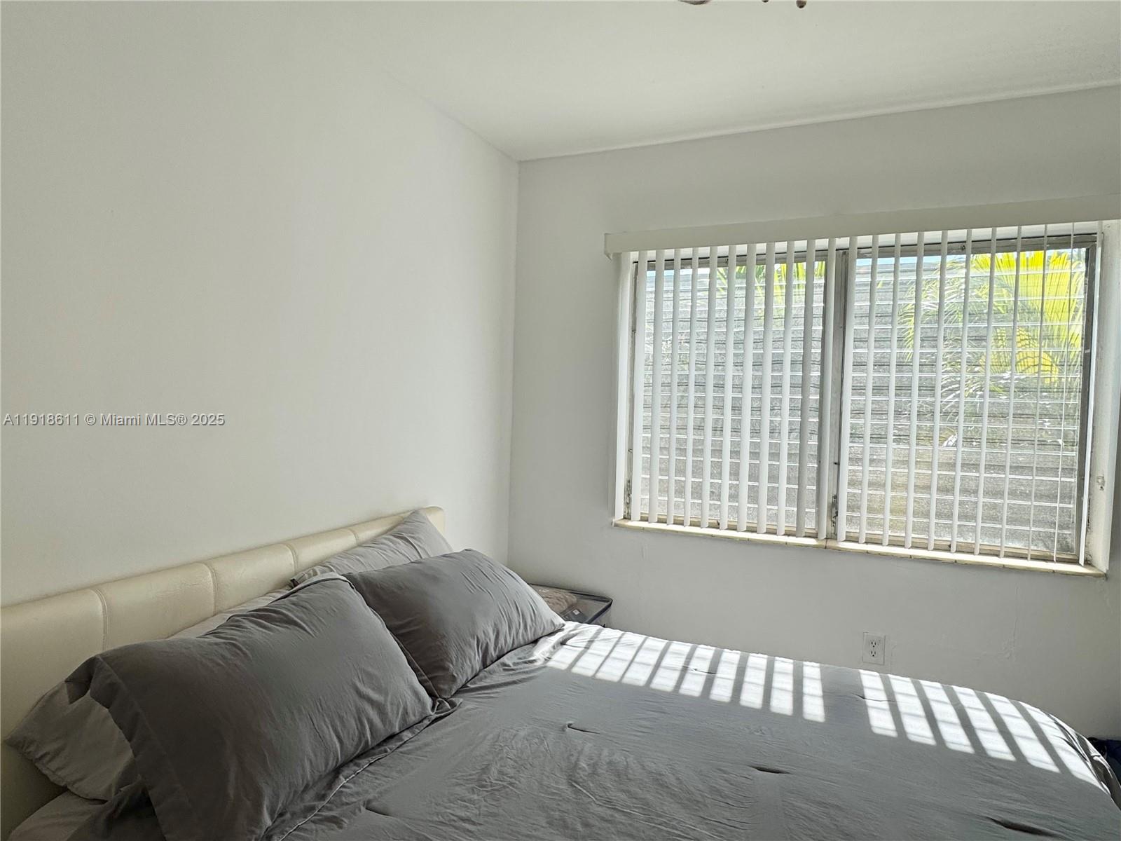 4740 Pine Tree Drive, Unit 32 Miami Beach, FL 33140 - Photo 15 of 20 a bedroom with a bed and a window