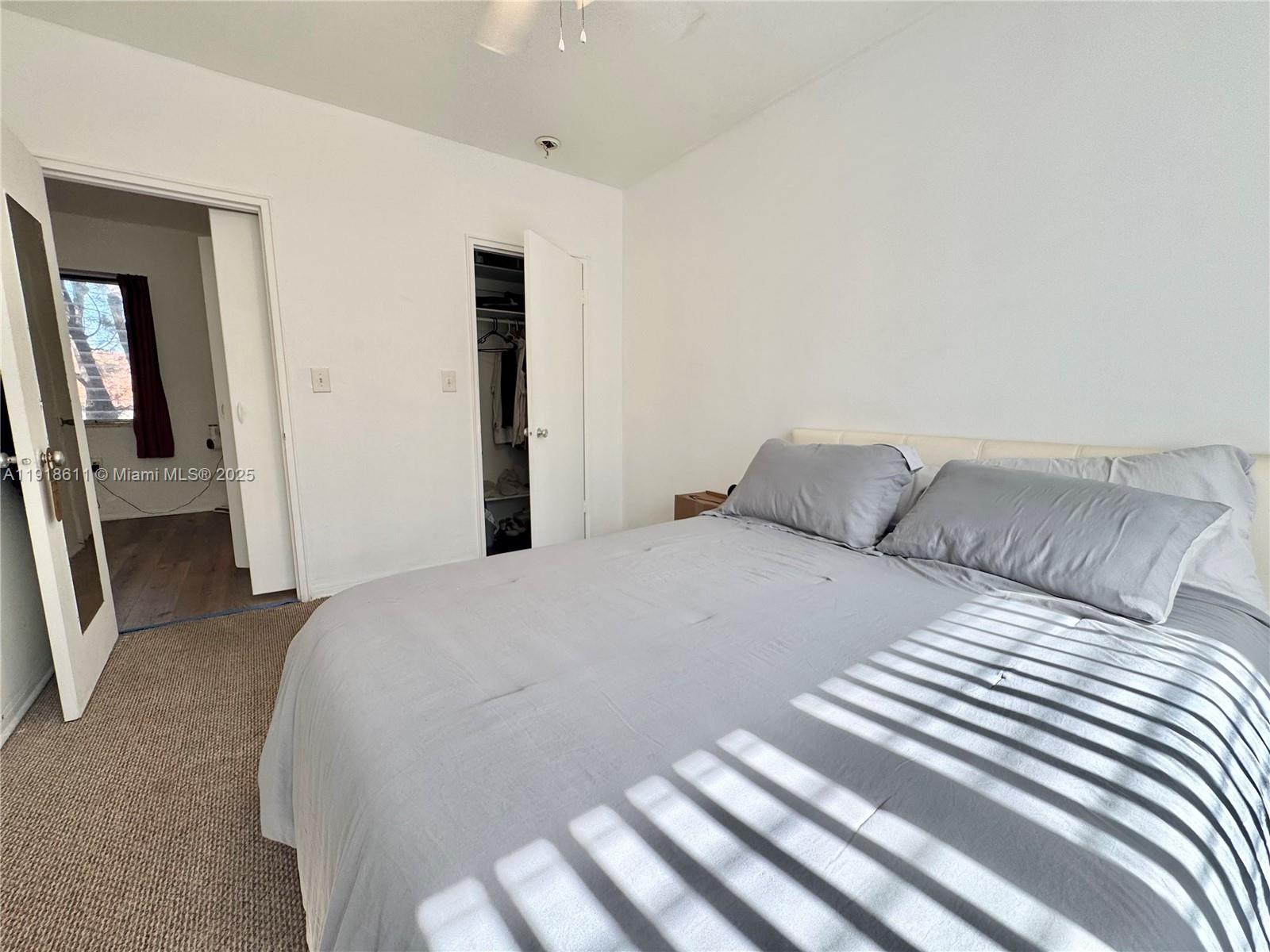 4740 Pine Tree Drive, Unit 32 Miami Beach, FL 33140 - Photo 16 of 20 a bedroom with a bed and a mirror