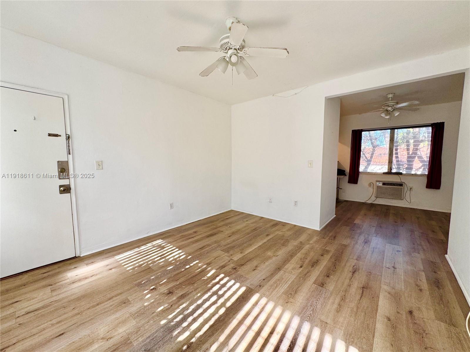 4740 Pine Tree Drive, Unit 32 Miami Beach, FL 33140 - Photo 9 of 20 a view of a room with wooden floor and a ceiling fan